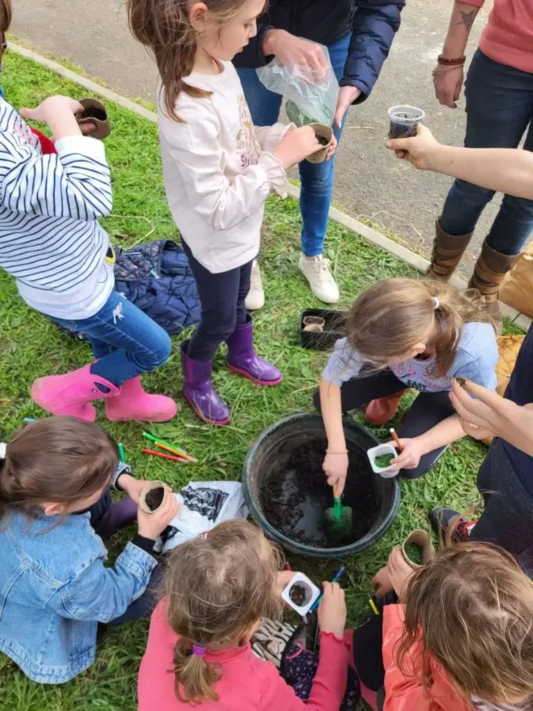 Enfants réalisant un atelier de plantation en permaculture